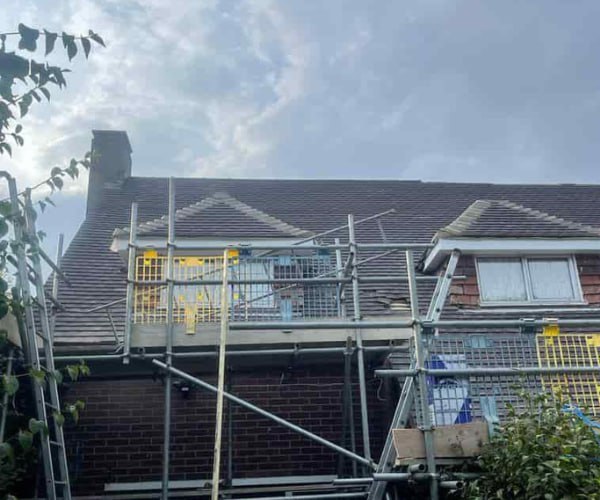 This is a photo of a roof with two dormers that is having some damaged tiles replaced. Works carried out by SAR Roofing Biggleswade